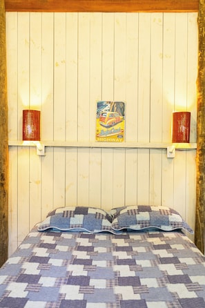 Et værelse med en seng, et skilt på væggen og to væglamper.