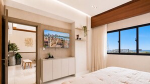 A modern bedroom with a large bed, a TV mounted on the wall, a window with a city view, and a wooden ceiling. - Niza City Tower Downtownsd Pool Gym Balcony (Santo Domingo)