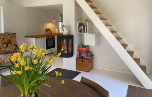 A living room with a sofa, a coffee table, a fireplace, a bookshelf, and a staircase. - Awesome home in Tisvildeleje with WiFi (Tisvildeleje)