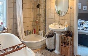 Ein Badezimmer mit Badewanne, Waschbecken, Dusche und Spiegel.