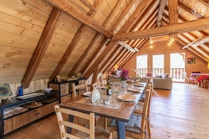 A wooden interior with a dining area, kitchen, and seating space. - La Grange Caroline - ENTREMONT LE VIEUX (ENTREMONT LE VIEUX)