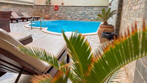 A pool area with lounge chairs, a pool, and potted plants. - 02 BR apartment with full roof sea view (Red Sea Governorate)
