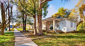 A single-story house with a porch, surrounded by trees and a grassy yard. - Steps2White Sandy beach/Familyfun/fishing/Games (Gulfport)
