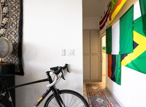 Ein Fahrrad an einer Wand, ein Globus und ein gemustertes Vorhang.