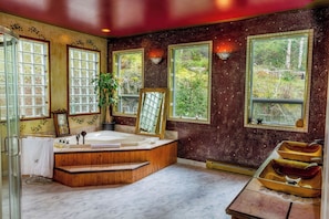 Un baño con una bañera grande, dos lavamanos y un espejo.