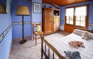 A bedroom with a bed, a chair, a wardrobe, a lamp, and a window. - Cozy home in Ginestet (Ginestet)