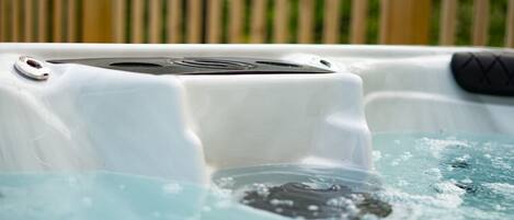 A hot tub with a control panel, surrounded by water.