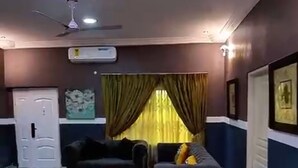 Un soggiorno con ventilatore a soffitto, divano e televisore.