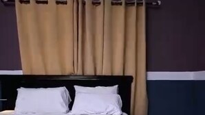 Un letto con biancheria bianca, una testiera e un condizionatore d'aria fissato al muro.