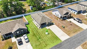 A residential area with houses, a driveway, and a parked car. - Whispering Waves in OIB! (Ocean Isle Beach)