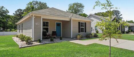 A single-story house with a front porch, a mailbox, and a small tree in the front yard.