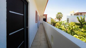 A corridor with a tiled floor, a black door on the left, and a white wall with a red trim. - The best house in cuautla morelos for families and groups of all sizes, (Cuautla)
