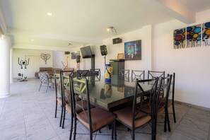 A dining area with a glass table, brown cushioned chairs, a vase, and wall art. - The best house in cuautla morelos for families and groups of all sizes, (Cuautla)