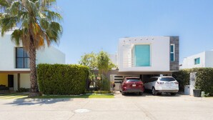 A modern two-story house with a garage, a red car, and a white car parked in front. - The best house in cuautla morelos for families and groups of all sizes, (Cuautla)