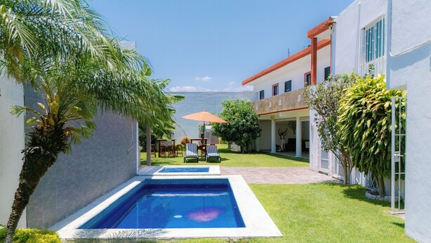 A pool with a view of the sea, a covered patio area, and a building with a white exterior. - The best house in cuautla morelos for families and groups of all sizes, (Cuautla)