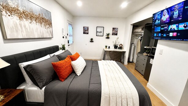 A modern bedroom with a bed, a desk, and a TV. - Cozy Private Suite • Near SMF Airport (Elverta)