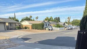 A residential street with houses, a sidewalk, and parked vehicles. - Cozy Private Suite • Near SMF Airport (Elverta)