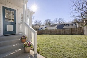 Ein Wohnhaus mit Veranda, Holzzaun und Rasengarten.