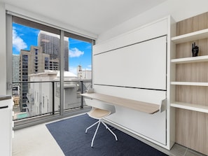A modern office space with a large window, a desk, and a chair. - Premium 2BR Condo | Beautiful City View (Miami)