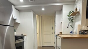 Een moderne keuken met roestvrijstalen apparatuur, een houten aanrecht en een prullenbak.