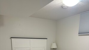 Een slaapkamer met een bed, nachtkastje en bedlampje.
