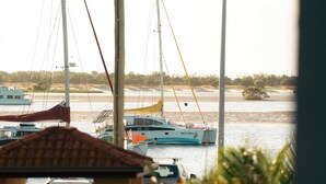 Ein Yachthafen mit mehreren Segelbooten, freie Sicht auf das Wasser und eine entfernte Küstenlinie.