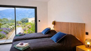 A bedroom with two beds, a view of a garden, and a wooden headboard. - Stunning home in Mollans-sur-Ouvèze with sauna (Mollans-sur-Ouvèze)