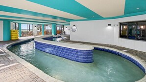 Una piscina interior de disseny corbat, un senyal de socorrista i vistes cap a l'exterior.