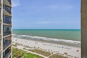 Une vue sur la plage depuis un immeuble doté de nombreux balcons donnant sur l’océan.