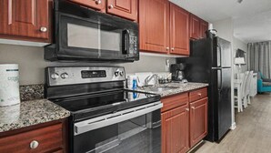 Eine moderne Küche mit integriertem Mikrowellenherd, Backofen und Kühlschrank.