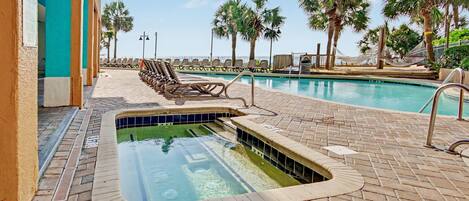 A swimming pool with a 3 FT depth marker, surrounded by lounge chairs and palm trees.