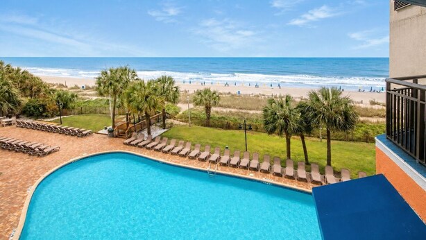 Una piscina con vista a la playa y al océano.