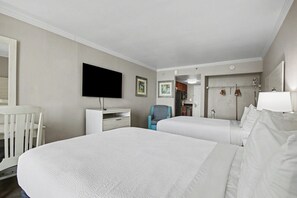 A hotel room with two beds, a TV, a desk, a chair, and a wardrobe. - Oceanfront Studio w/ Two Queens + Beach & Pools (Myrtle Beach)