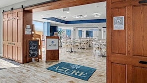 A restaurant interior with wooden doors, a chalkboard sign, and a QR code for the menu. - Oceanfront Studio w/ Two Queens + Beach & Pools (Myrtle Beach)