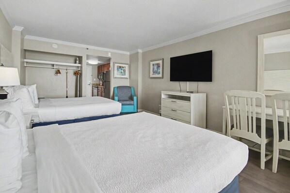 A hotel room with two beds, a desk, a chair, a television, and a bathroom visible through an open door. - Oceanfront Studio w/ Two Queens + Beach & Pools (Myrtle Beach)