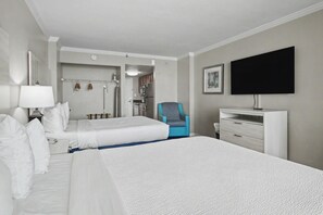 A hotel room with two beds, a desk, a chair, a TV, and a bathroom visible through an open door. - Oceanfront Studio w/ Two Queens + Beach & Pools (Myrtle Beach)