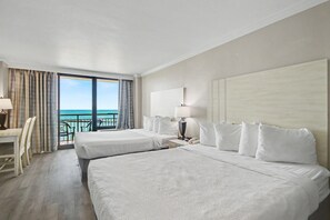 A hotel room with two beds, a desk, and a view of the ocean. - Oceanfront Studio w/ Two Queens + Beach & Pools (Myrtle Beach)