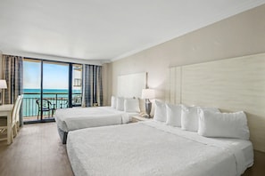 A hotel room with two beds, a balcony with a view of the sea, a desk, and a chair. - Oceanfront Studio w/ Two Queens + Beach & Pools (Myrtle Beach)