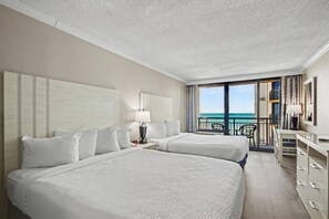 A hotel room with two beds, a desk, a chair, and a balcony with a view of the sea. - Oceanfront Studio w/ Two Queens + Beach & Pools (Myrtle Beach)