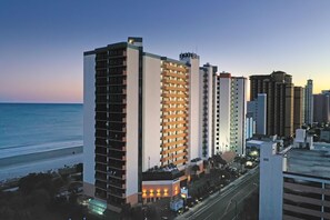 A high-rise hotel with multiple floors, a beach view, and a parking area. - Oceanfront Studio w/ Two Queens + Beach & Pools (Myrtle Beach)