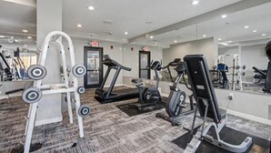 A gym with cardio machines, weightlifting equipment, and mirrors. - Oceanfront Studio w/ Two Queens + Beach & Pools (Myrtle Beach)