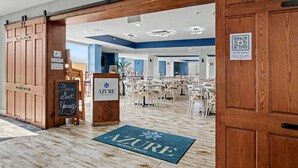 A restaurant interior with wooden doors, a chalkboard sign, and a QR code for the menu. - Oceanfront Studio w/ Two Queens + Beach & Pools (Myrtle Beach)