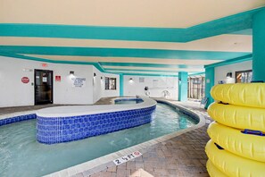 An indoor swimming pool with a blue tiled hot tub area, a lifeguard station, and a no lifeguard sign. - Oceanfront Studio w/ Two Queens + Beach & Pools (Myrtle Beach)