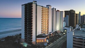 A high-rise hotel with multiple floors, a beach view, and a parking area. - Oceanfront Studio w/ Two Queens + Beach & Pools (Myrtle Beach)