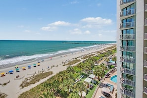 A beach resort with a pool, beach umbrellas, and a pier. - Oceanfront 7th Floor Studio w/ Balcony & Kitchenette | Dog Friendly (Myrtle Beach)