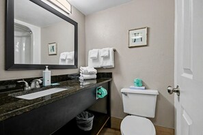 A bathroom with a sink, mirror, toilet, and towels. - Oceanfront Studio w/ Two Queens + Beach & Pools (Myrtle Beach)
