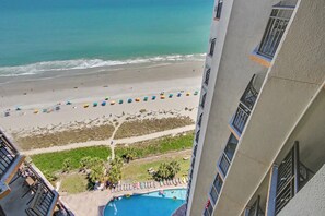 A beach view from a building with a swimming pool and beach umbrellas. - Ocean View King Room + Beach Access + Lazy River (Myrtle Beach)