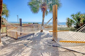 Ein Strand mit Hängematten und Holzgeländern.