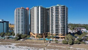 Un hotel di grandi dimensioni con numerosi piani, balconi e una zona piscina.