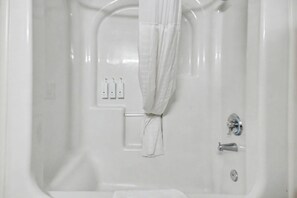A white bathtub with a shower curtain, a towel rack, and a faucet. - Ocean View King Room + Beach Access + Lazy River (Myrtle Beach)